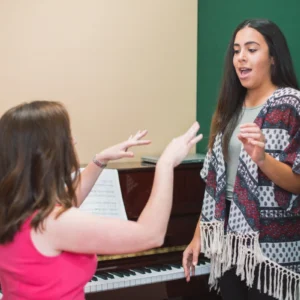 Singing lesson with teacher and student practicing.