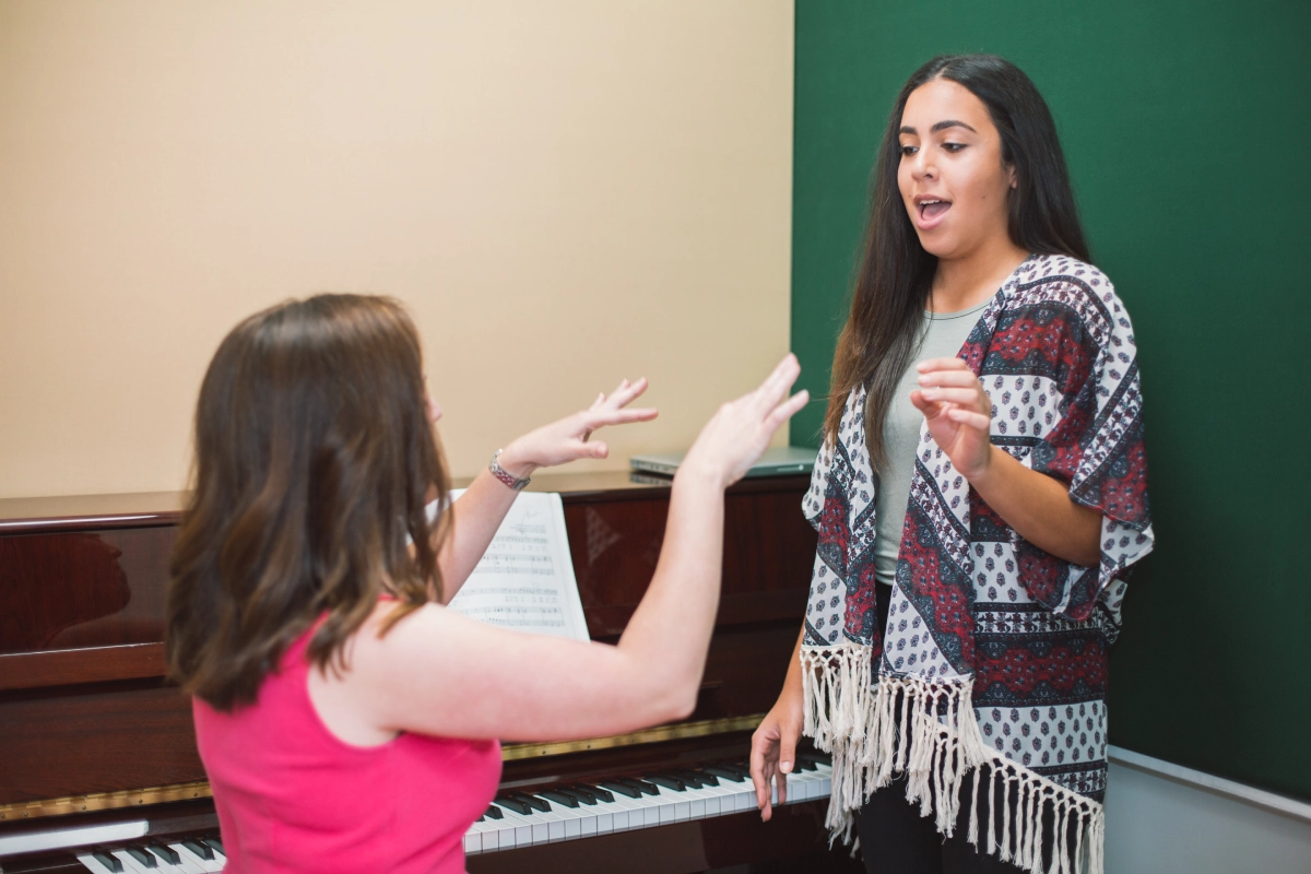 Singing lesson with teacher and student practicing.